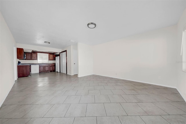 unfurnished living room with baseboards