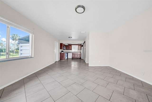 unfurnished living room with baseboards and light tile patterned floors