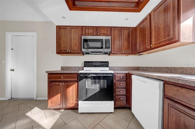 kitchen featuring light tile patterned floors, white dishwasher, range with electric cooktop, brown cabinetry, and stainless steel microwave