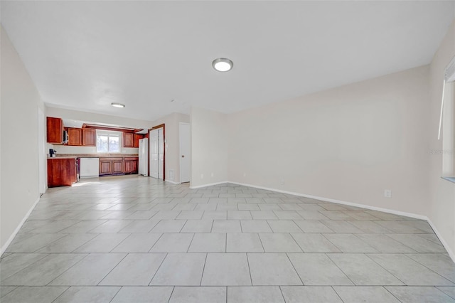 unfurnished living room featuring light tile patterned floors and baseboards