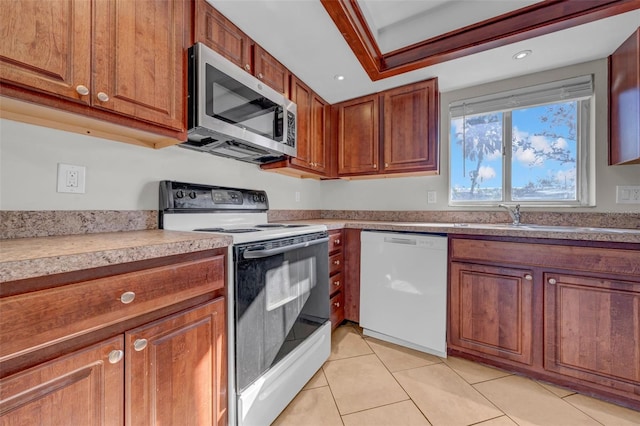 kitchen featuring brown cabinets, light tile patterned floors, recessed lighting, light countertops, and white appliances