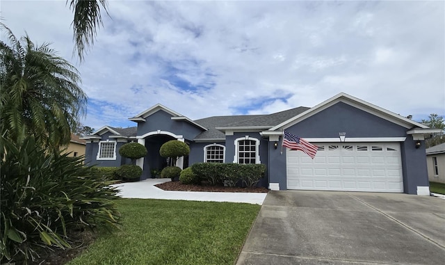 ranch-style house featuring a garage, a front yard, concrete driveway, and stucco siding