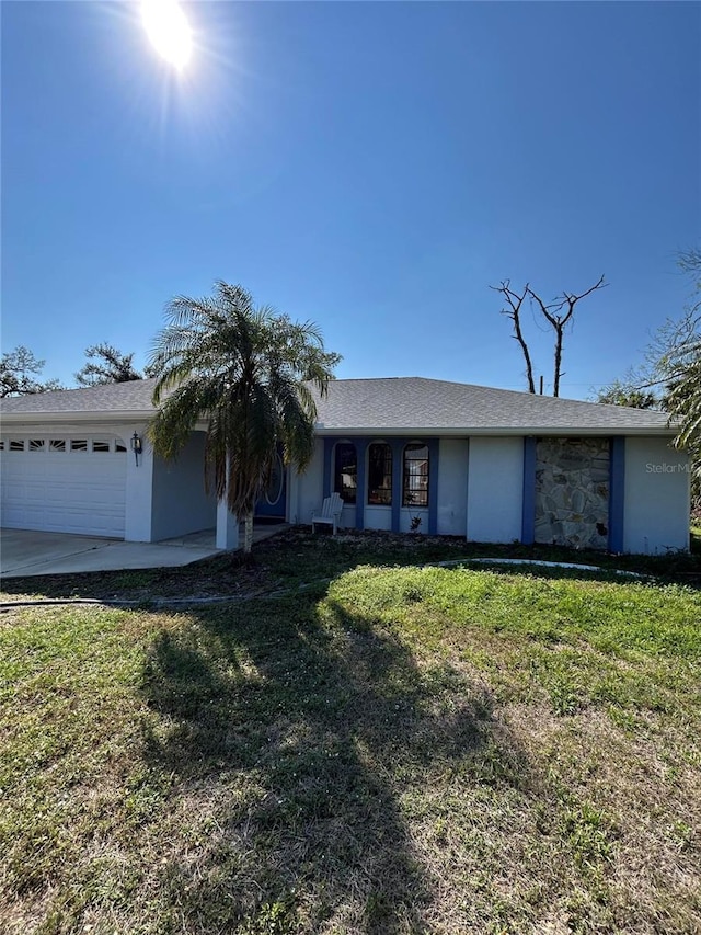 ranch-style home with a garage, a front yard, concrete driveway, and stucco siding