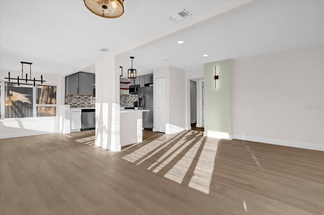 unfurnished living room with baseboards, recessed lighting, visible vents, and light wood-style floors