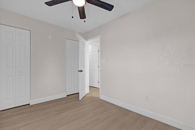 unfurnished bedroom featuring light wood-style floors, baseboards, and a ceiling fan