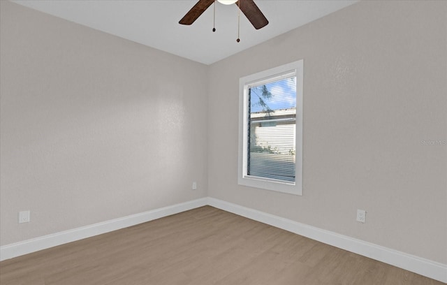 spare room with ceiling fan, baseboards, and wood finished floors