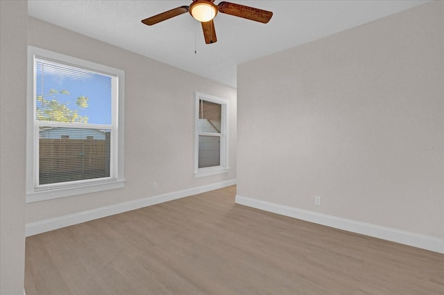 unfurnished room featuring a ceiling fan, baseboards, and wood finished floors