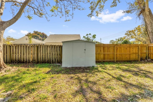 view of yard with an outbuilding, a fenced backyard, and a storage unit