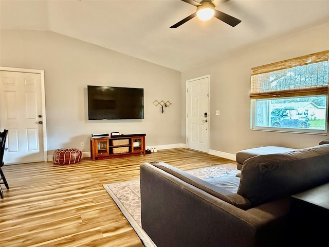 living area featuring light wood-type flooring, lofted ceiling, ceiling fan, and baseboards