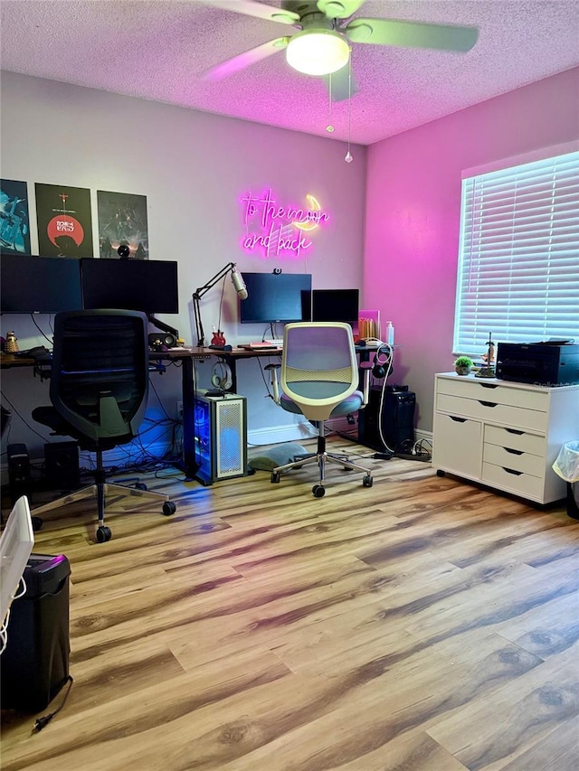 office featuring a textured ceiling, wood finished floors, a ceiling fan, and baseboards