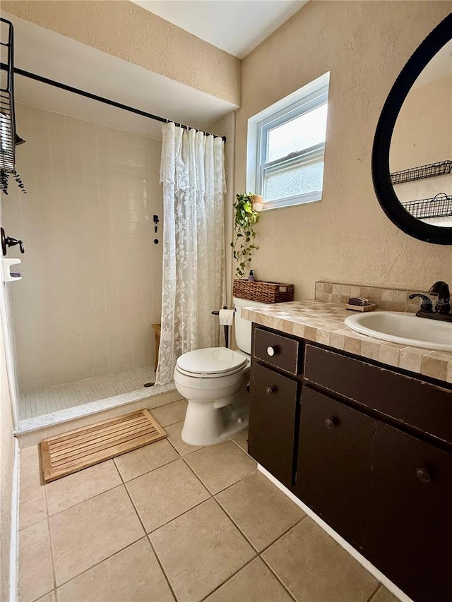 bathroom with tile patterned flooring, a textured wall, a shower stall, and toilet