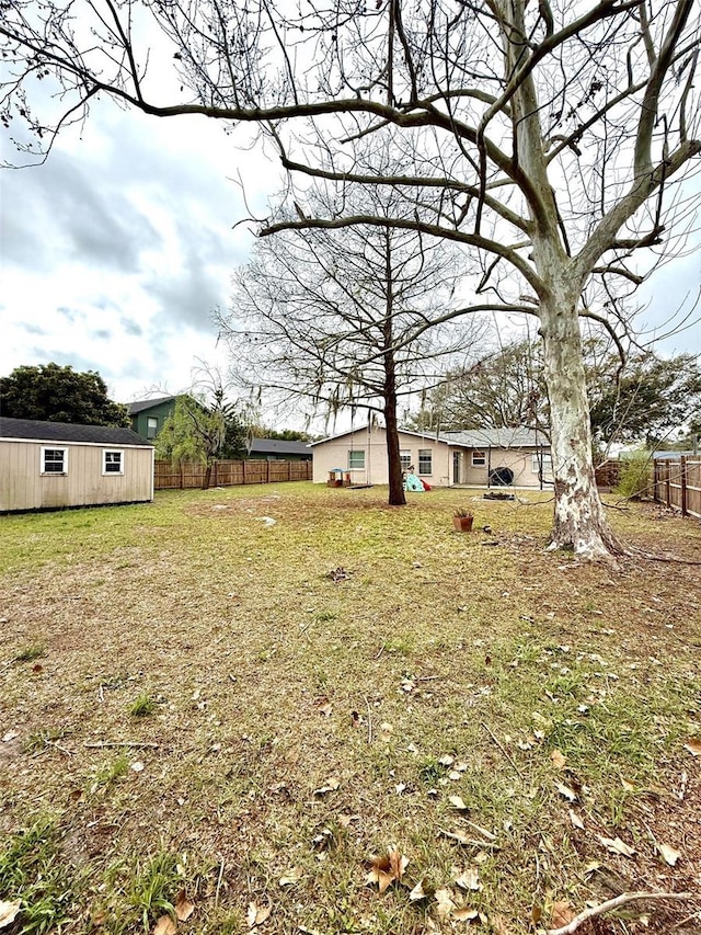 view of yard with fence and an outdoor structure