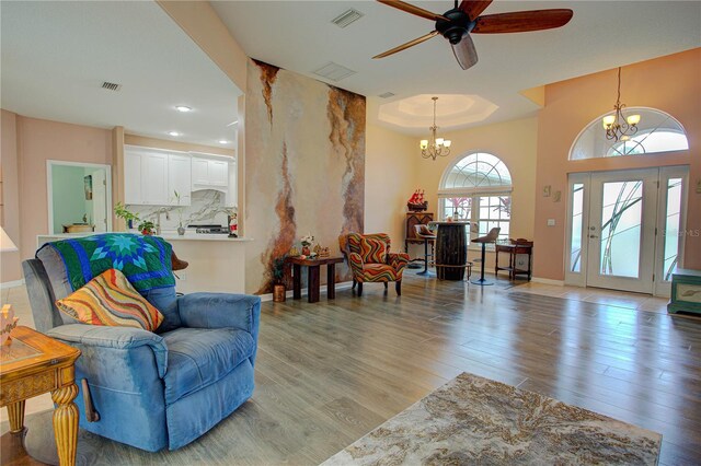 interior space featuring recessed lighting, visible vents, wood finished floors, baseboards, and ceiling fan with notable chandelier