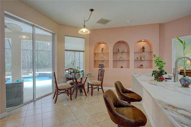 dining room featuring light tile patterned floors, visible vents, and built in features