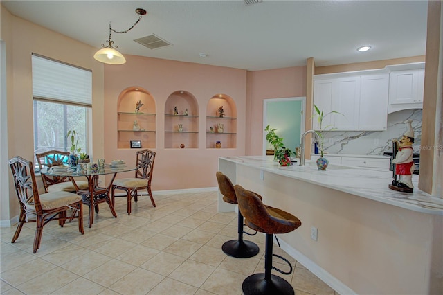 dining room with built in features, visible vents, baseboards, and light tile patterned floors