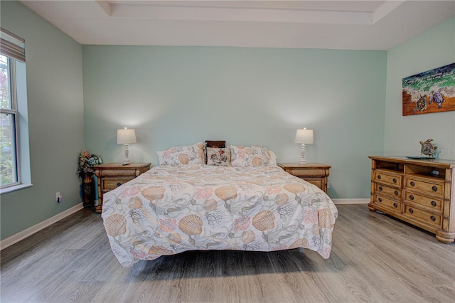 bedroom with baseboards and wood finished floors