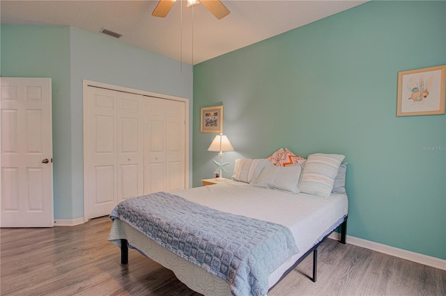 bedroom with baseboards, a closet, visible vents, and wood finished floors