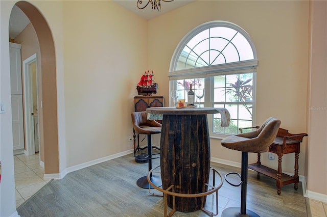 dining room with light wood-type flooring, baseboards, and arched walkways