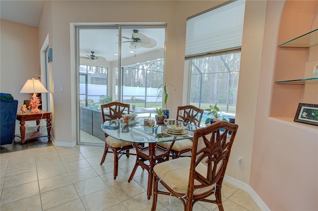 dining area with light tile patterned floors, a ceiling fan, and baseboards