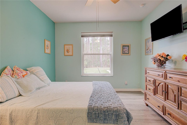 bedroom featuring ceiling fan, light wood-style flooring, and baseboards