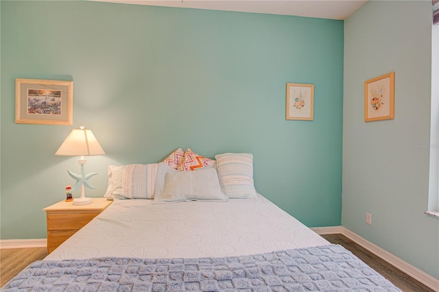 bedroom featuring baseboards and wood finished floors