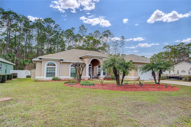 view of front of house with stucco siding, concrete driveway, a front yard, fence, and a garage