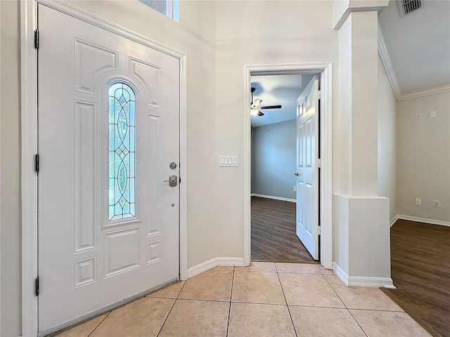 foyer entrance with baseboards, visible vents, a ceiling fan, crown molding, and light tile patterned flooring