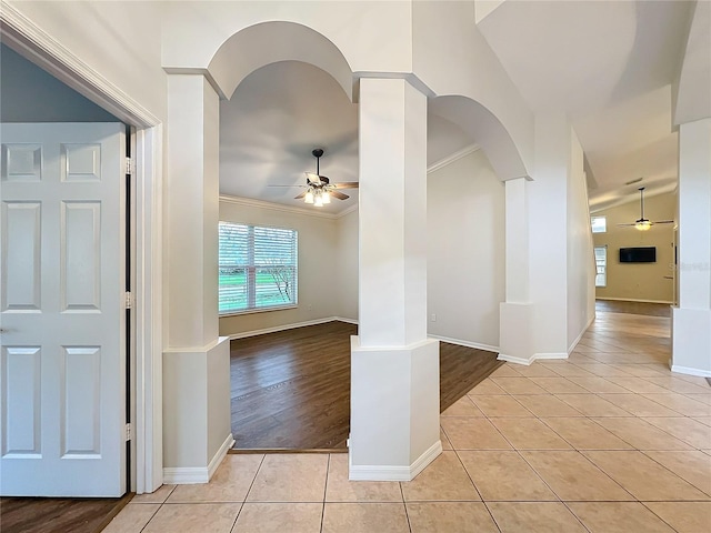 spare room with vaulted ceiling, light tile patterned flooring, a ceiling fan, and crown molding