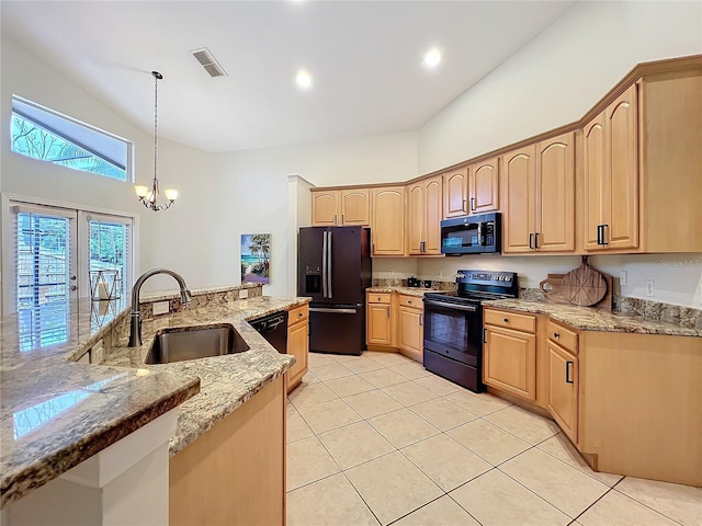 kitchen featuring black appliances, light brown cabinets, and visible vents