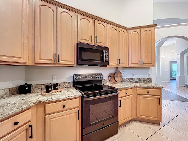 kitchen with black appliances, light tile patterned floors, light stone counters, and light brown cabinetry