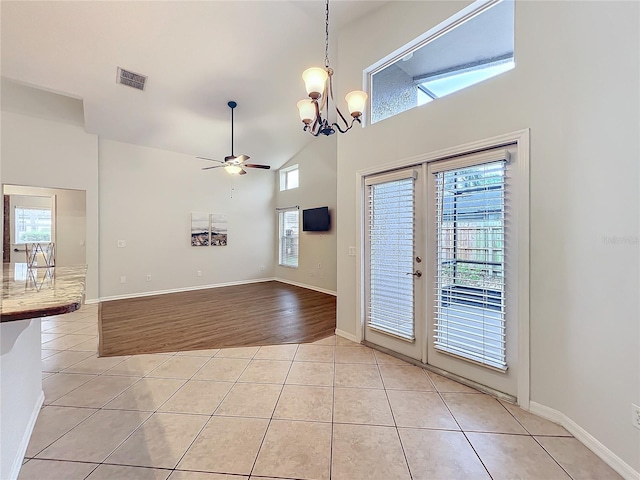 interior space featuring light tile patterned floors, plenty of natural light, visible vents, and high vaulted ceiling