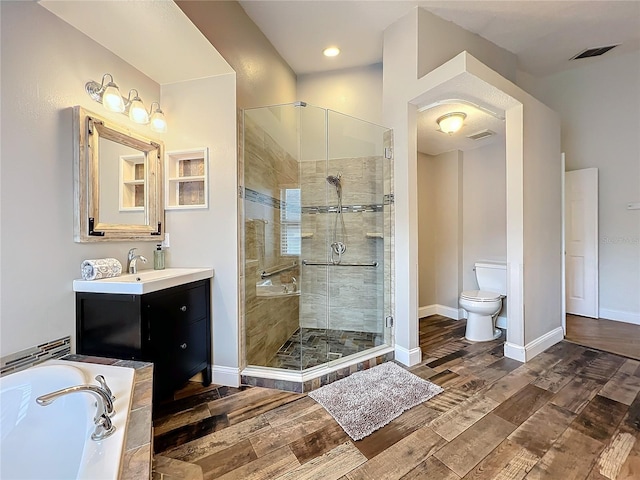 bathroom featuring toilet, wood finished floors, a shower stall, and visible vents