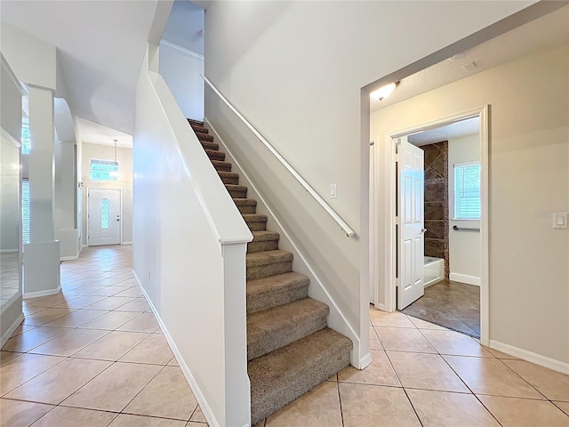 stairway featuring baseboards and tile patterned floors