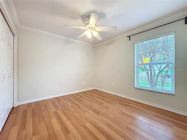 unfurnished bedroom with baseboards, a ceiling fan, light wood-style flooring, ornamental molding, and a closet