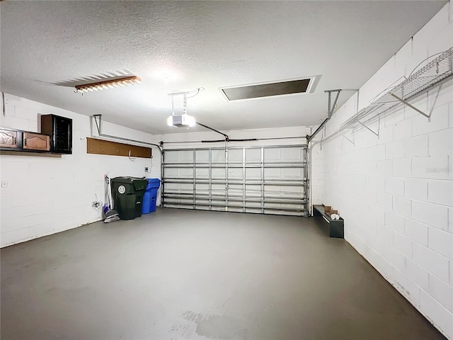 garage with concrete block wall and a garage door opener