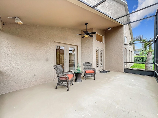 view of patio with a lanai, a ceiling fan, and french doors