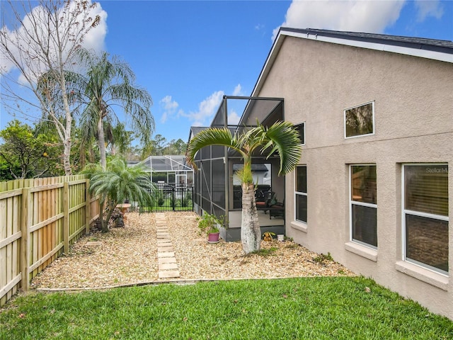 view of yard featuring glass enclosure and a fenced backyard