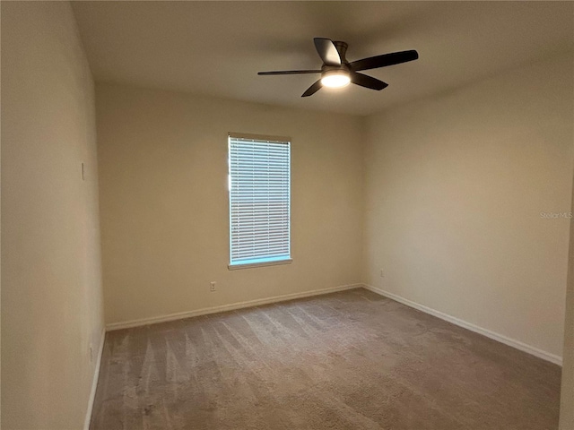 unfurnished room featuring carpet, baseboards, and a ceiling fan