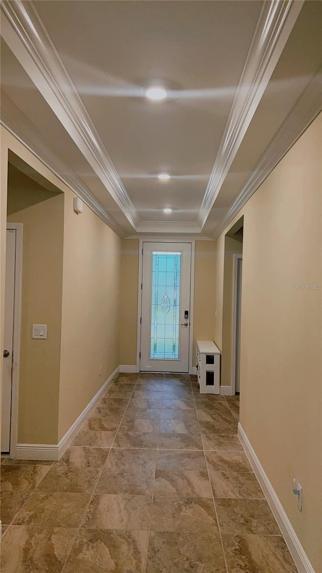 entryway featuring baseboards, a tray ceiling, and crown molding