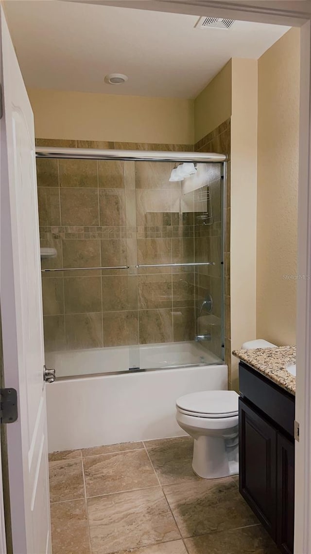 full bathroom featuring toilet, enclosed tub / shower combo, visible vents, and vanity