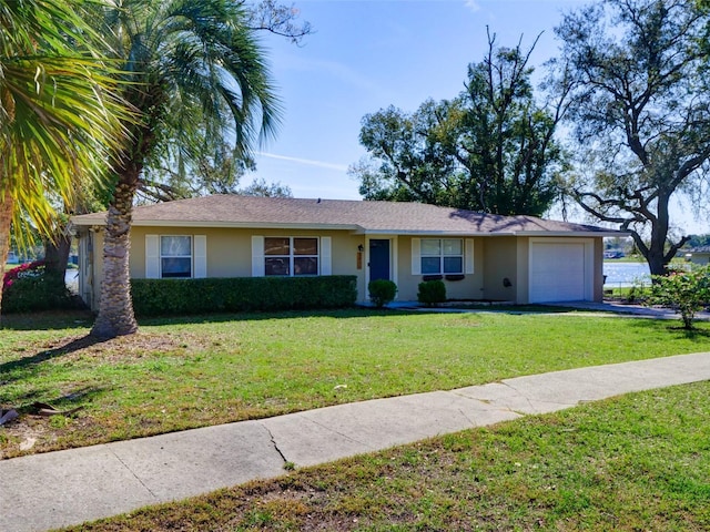 single story home with a garage, a front yard, concrete driveway, and stucco siding