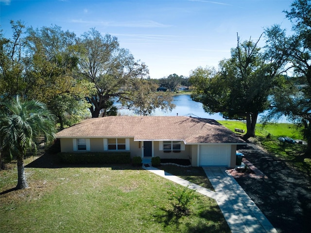 ranch-style home featuring a garage, driveway, a front yard, and stucco siding