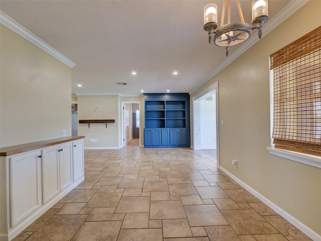 spare room with ornamental molding, an inviting chandelier, visible vents, and baseboards