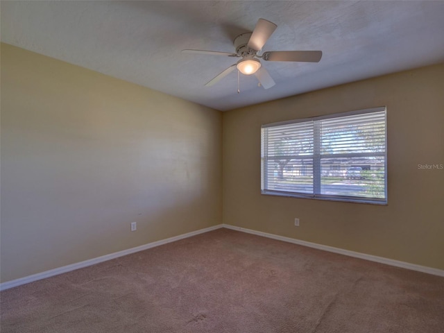 empty room with carpet floors, ceiling fan, and baseboards