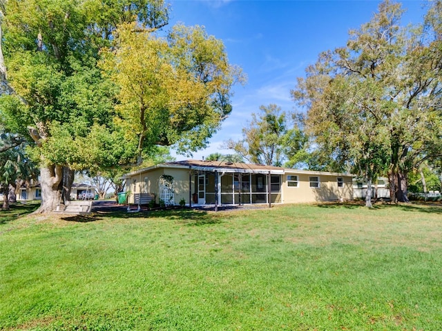 back of house with a sunroom and a yard