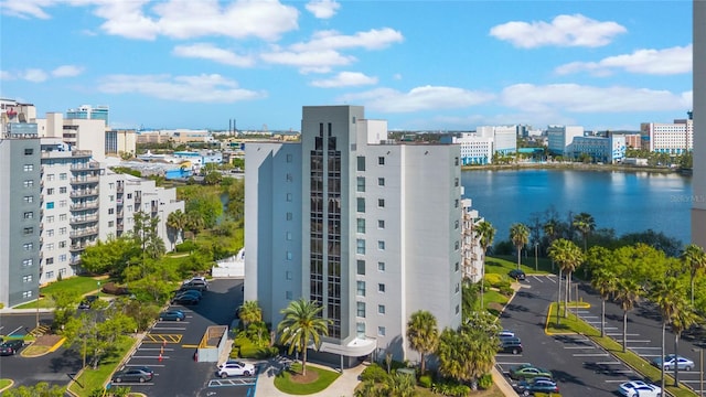 view of property with uncovered parking, a view of city, and a water view