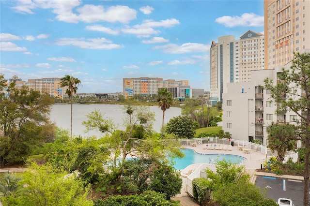 community pool featuring a view of city, fence, and a water view