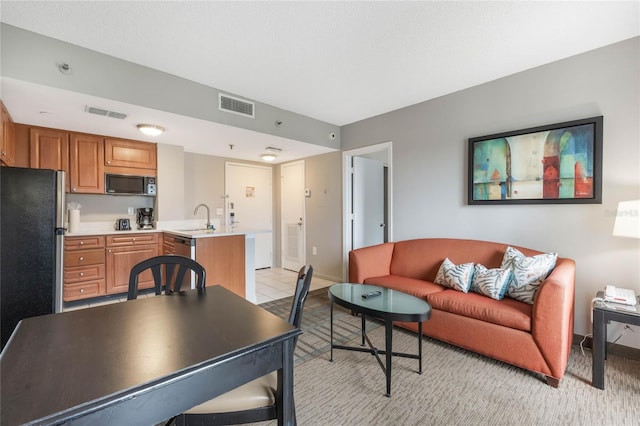 living area with light tile patterned floors, visible vents, and baseboards