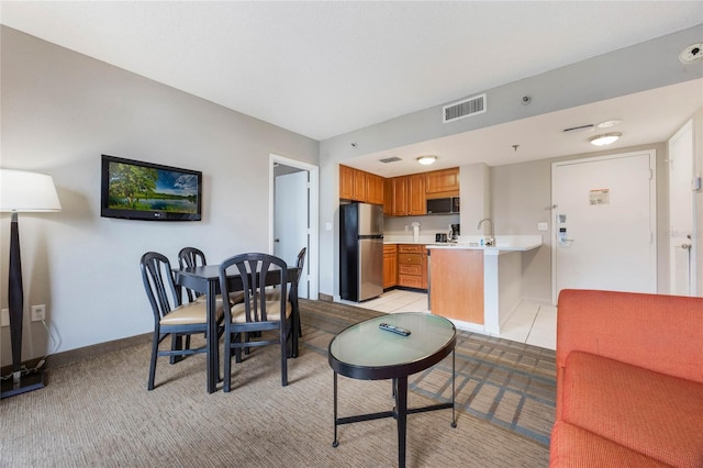 dining space with light colored carpet, baseboards, and visible vents