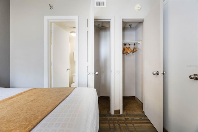 bedroom featuring visible vents and two closets